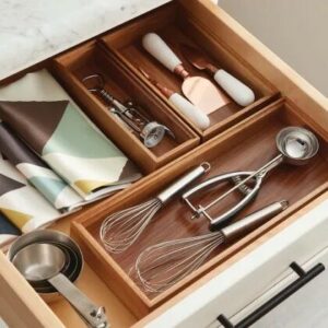 picture of an open kitchen drawer with whisks and other utensils