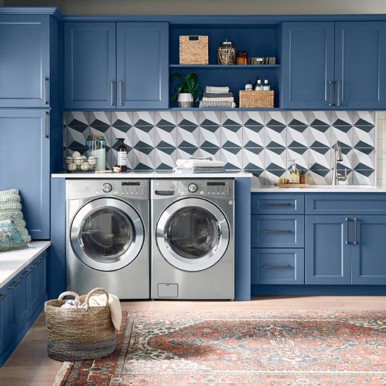 a laundry room with blue cabinets and washing machines
